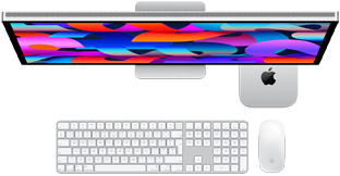 Mac mini wsunięty pod monitor Studio Display, klawiatura Magic Keyboard z polem numerycznym, mysz Magic Mouse