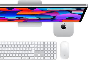 Mac mini wsunięty pod monitor Studio Display, klawiatura Magic Keyboard z polem numerycznym, mysz Magic Mouse